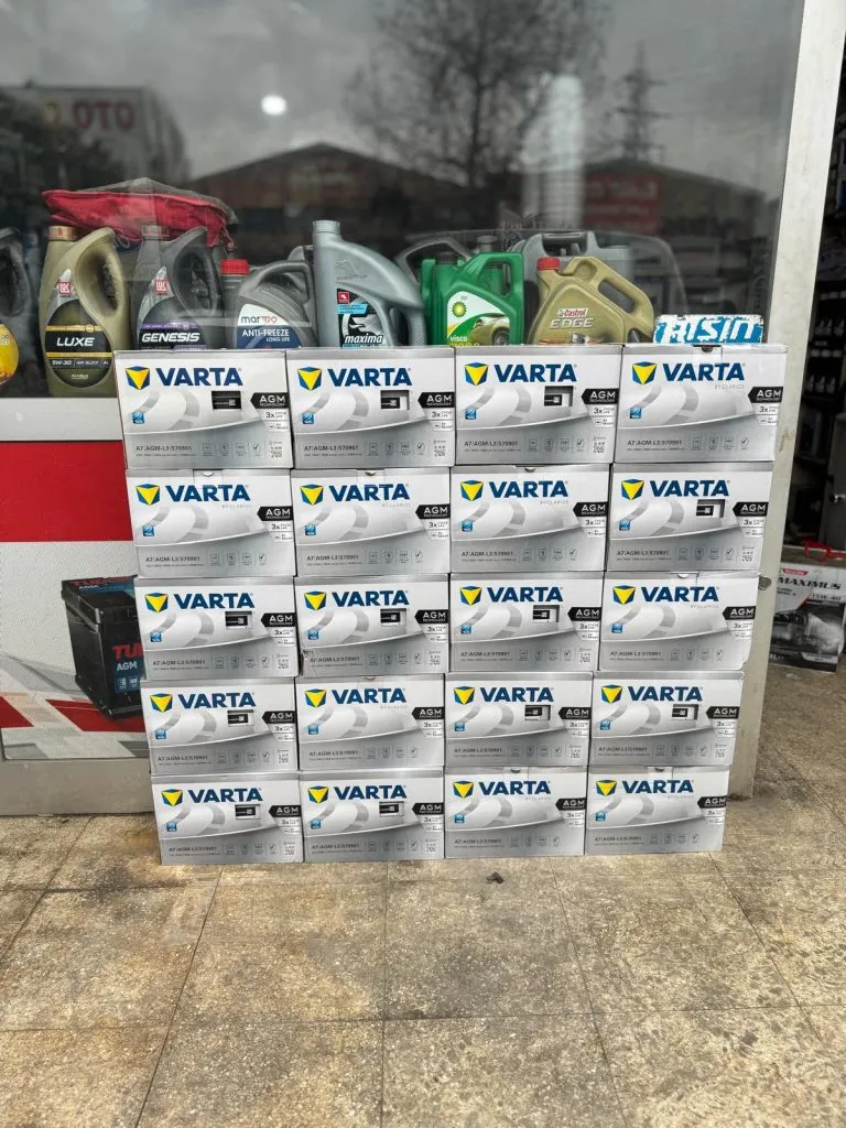 Vitrinde Varta Blue Dynamic akü kutuları, üstte motor yağı bidonları