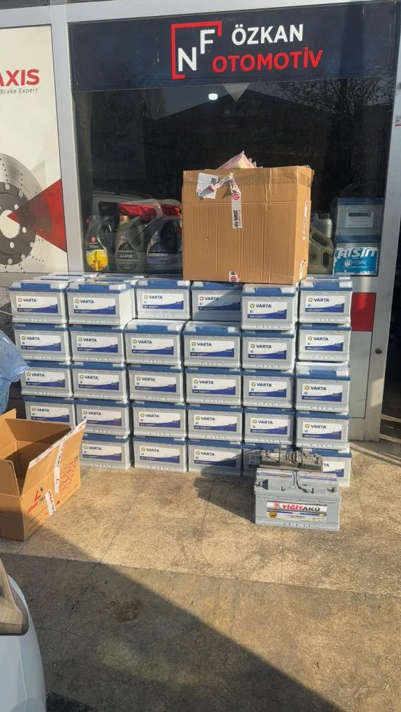 NF Özkan Otomotiv mağaza girişi önünde akü kutuları istifi